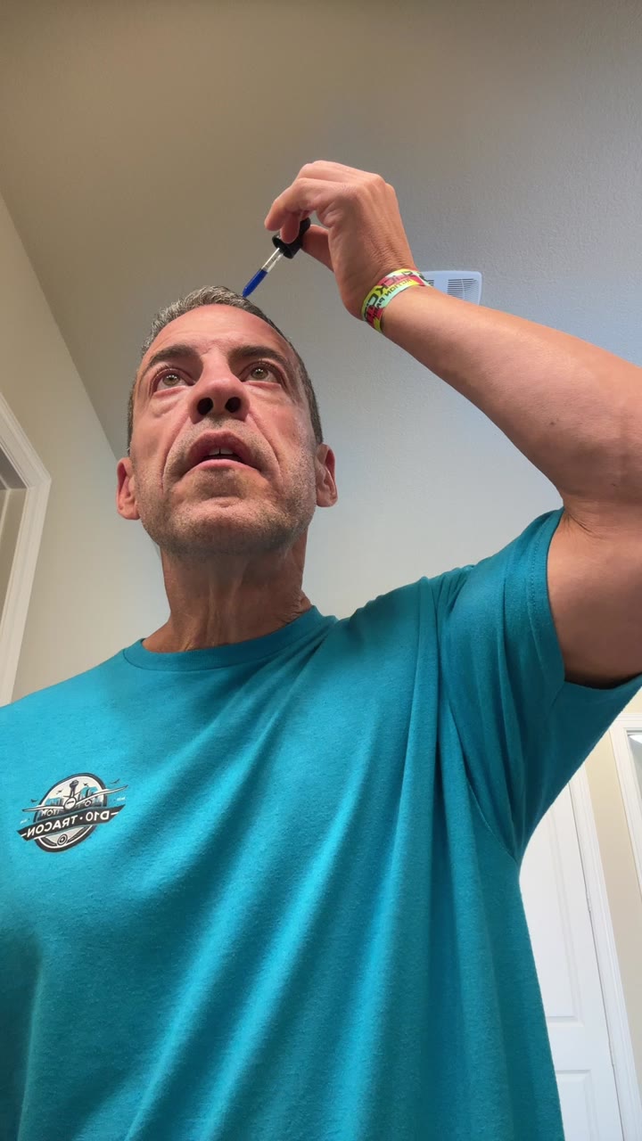 Matt, founder of Copper Crown Labs, applying copper peptide scalp serum with a dropper.